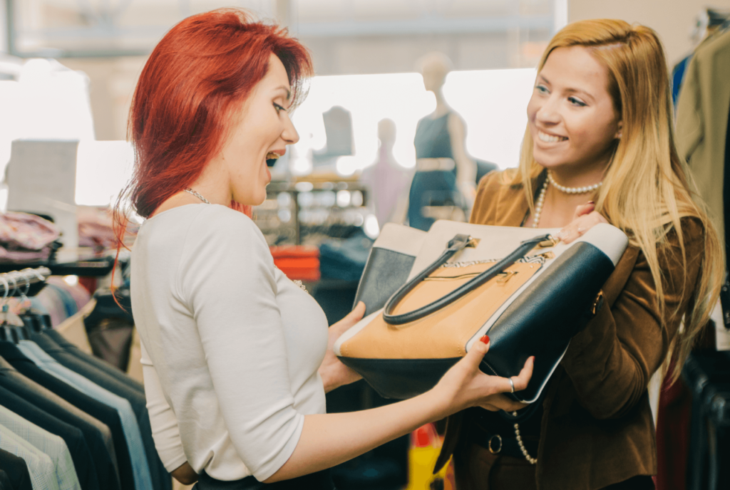 Funcionária entrega produto à cliente feliz